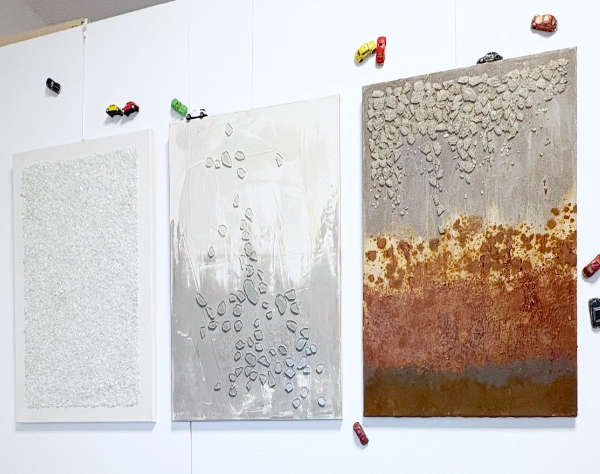 Mehrere Werke der Serie „GlasArt“, basierend auf Glassplittern von VW-Käfer Scheiben, in verschiedenen farblichen Ausführungen und Rost.