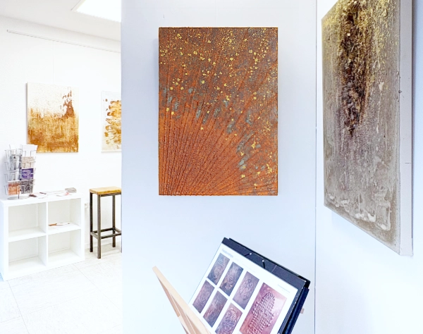 Verschiedene Werke mit Tiefenwirkung durch Folie, Rost, anderen Materialien und Goldfarbe auf Leinwand. 